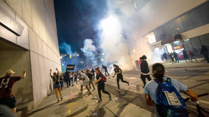 Protesters scramble on Fourth Street as police fire tear gas on either side of the protesters in uptown Charlotte on June 2, 2020. JOSHUA KOMER THE CHARLOTTE OBSERVER