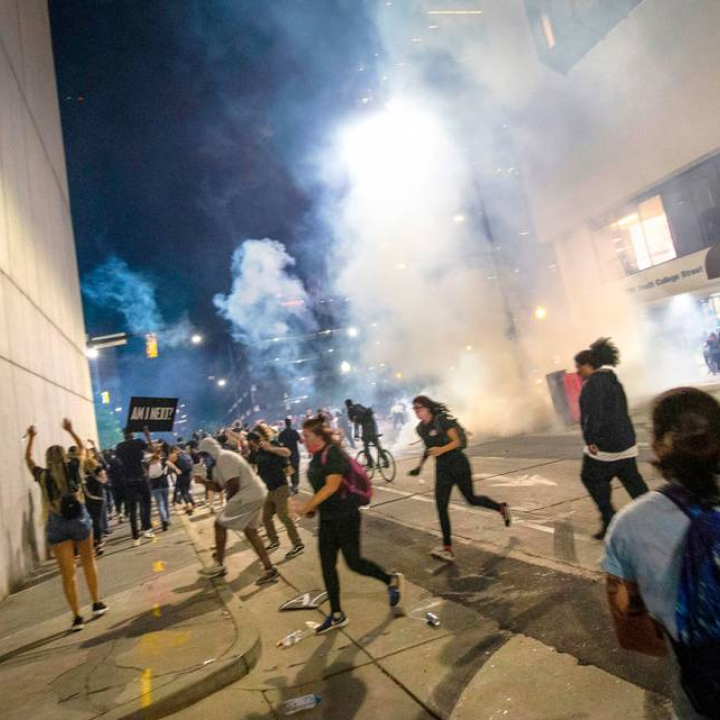 Protesters scramble on Fourth Street as police fire tear gas on either side of the protesters in uptown Charlotte on June 2, 2020. JOSHUA KOMER THE CHARLOTTE OBSERVER